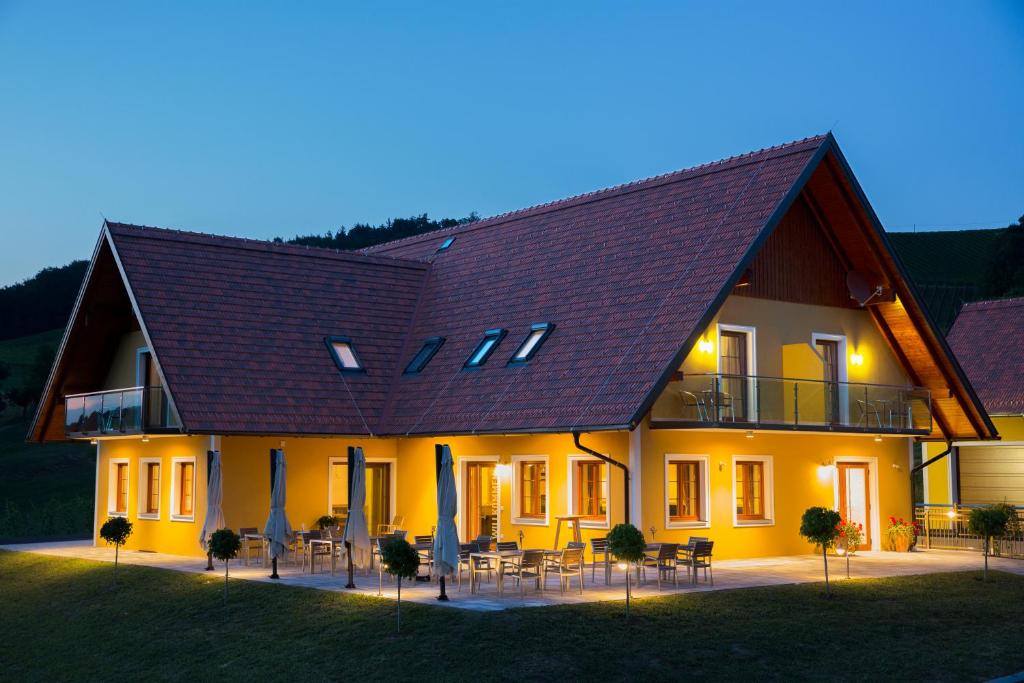 a large house with tables and chairs in front of it at Weingut-Gästezimmer UHL in Ratsch an der Weinstraße