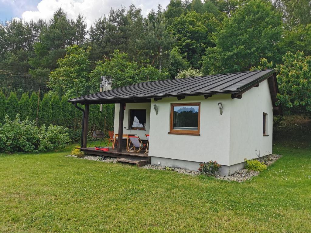 uma pequena casa branca com um telhado preto em Domek u Cioci Meli em Brodnica Dolna