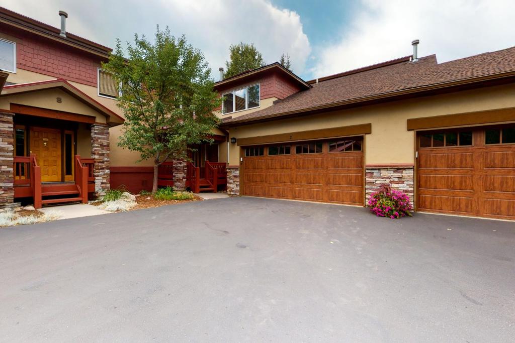 a house with a driveway and a garage at Cascades Townhomes by Steamboat Resorts in Steamboat Springs