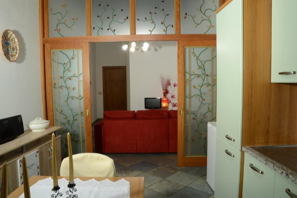 - une cuisine avec un canapé rouge dans une chambre dans l'établissement Palazzo Bufalari appartamento in centro storico, à Città della Pieve