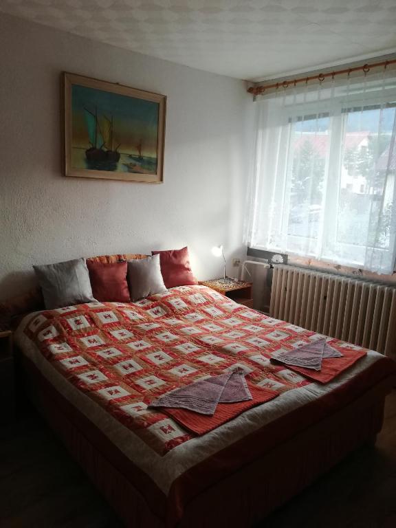 een slaapkamer met een bed met een rode quilt bij Privat Ludmila in Liptovská Teplička