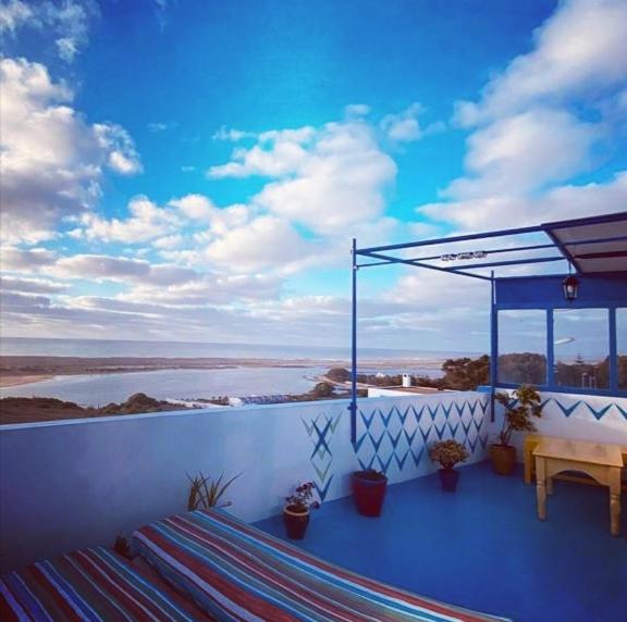 een balkon met een tafel en uitzicht op het water bij chez souad in Oualidia