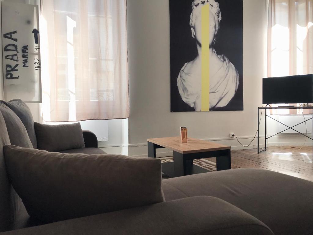 uma sala de estar com um sofá e uma mesa em Appartement standing em Nevers