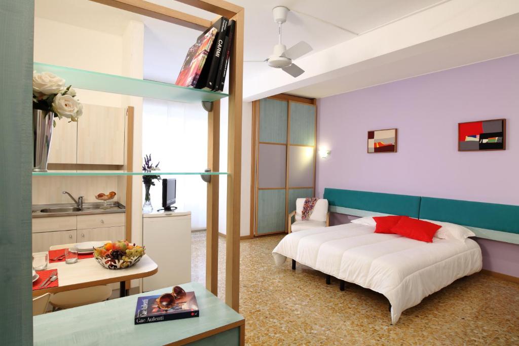 1 dormitorio con cama, mesa y cocina en Residence Giusti 6, en Milán