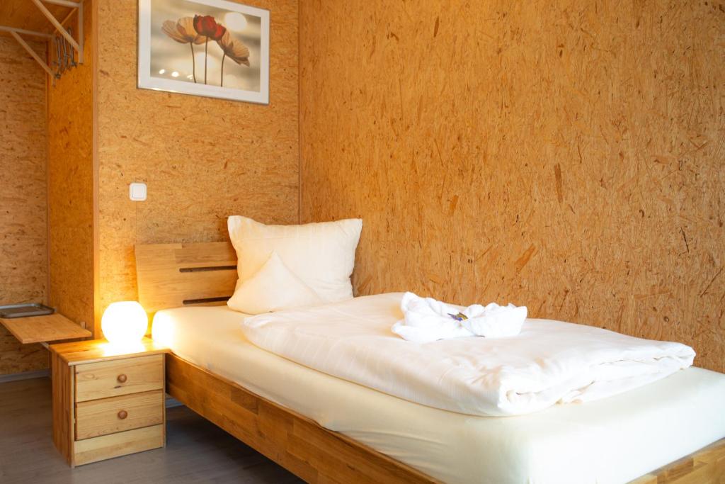 een slaapkamer met een bed met twee handdoeken erop bij Hotel Vicinity in Neubrücke