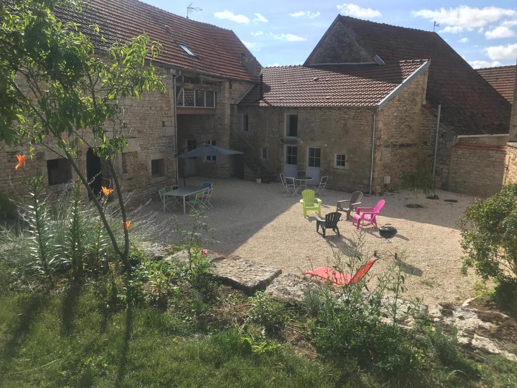 un patio al aire libre con sillas y mesas frente a un edificio en Relais de la truffière, en Villaines-en-Duesmois