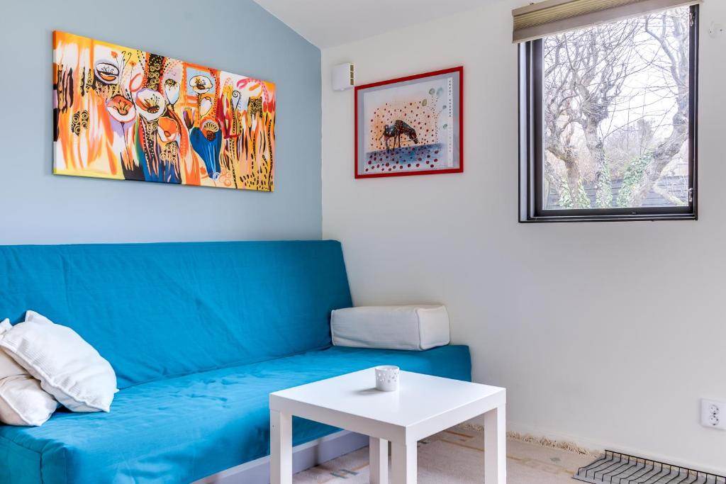 een woonkamer met een blauwe bank en een tafel bij Cosy stay in southern Malmo in Malmö