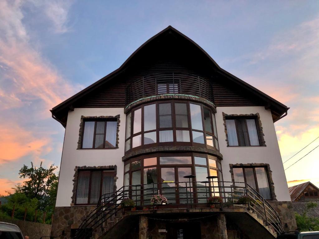 a large white house with a gambrel roof at Vila FAN Confort in Vişeu de Sus