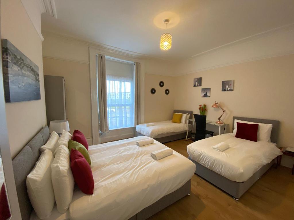 a bedroom with a large bed and a couch and a bed at Serviced Property Apartment 1 in Plymouth