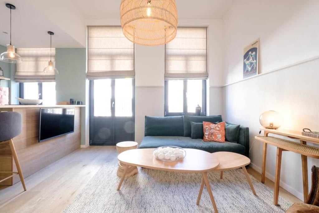 uma sala de estar com um sofá azul e uma mesa em Fabulous studio in Châtelain area with balcony em Bruxelas