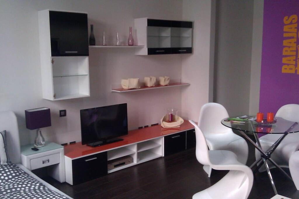 uma sala de estar com uma secretária com uma televisão e cadeiras em Beautiful Apartment in Gran Via em Madri