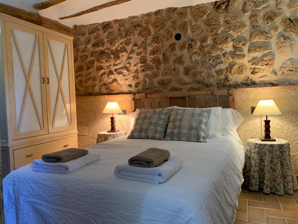 a bedroom with a large bed with towels on it at Casa Rural Ladrón de Semillas in Elche de la Sierra