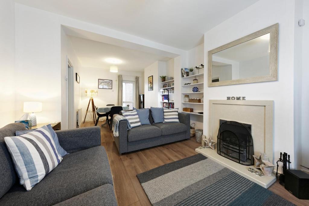 a living room with a couch and a fireplace at Pepperpot Cottage in Whitstable