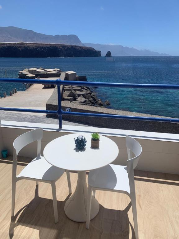 - une table et des chaises blanches sur un balcon donnant sur l'océan dans l'établissement Touch the Sea, à Sardina