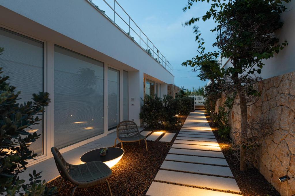 a garden with chairs and a walkway next to a building at Santa Caterina - Dimora sul mare in Polignano a Mare