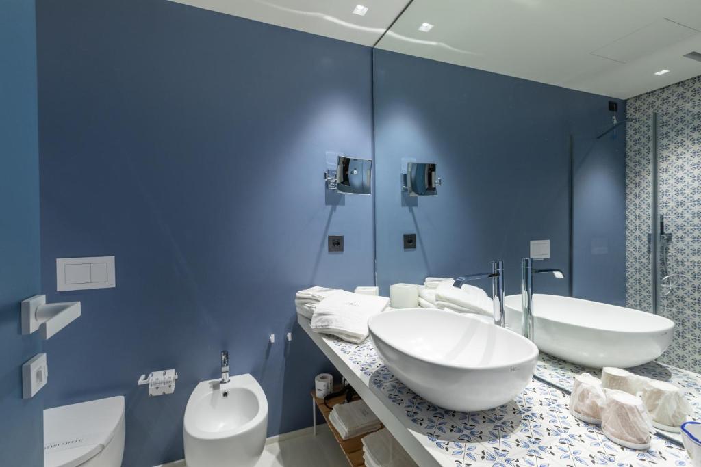 a blue bathroom with two sinks and a toilet at Santa Caterina - Dimora sul mare in Polignano a Mare
