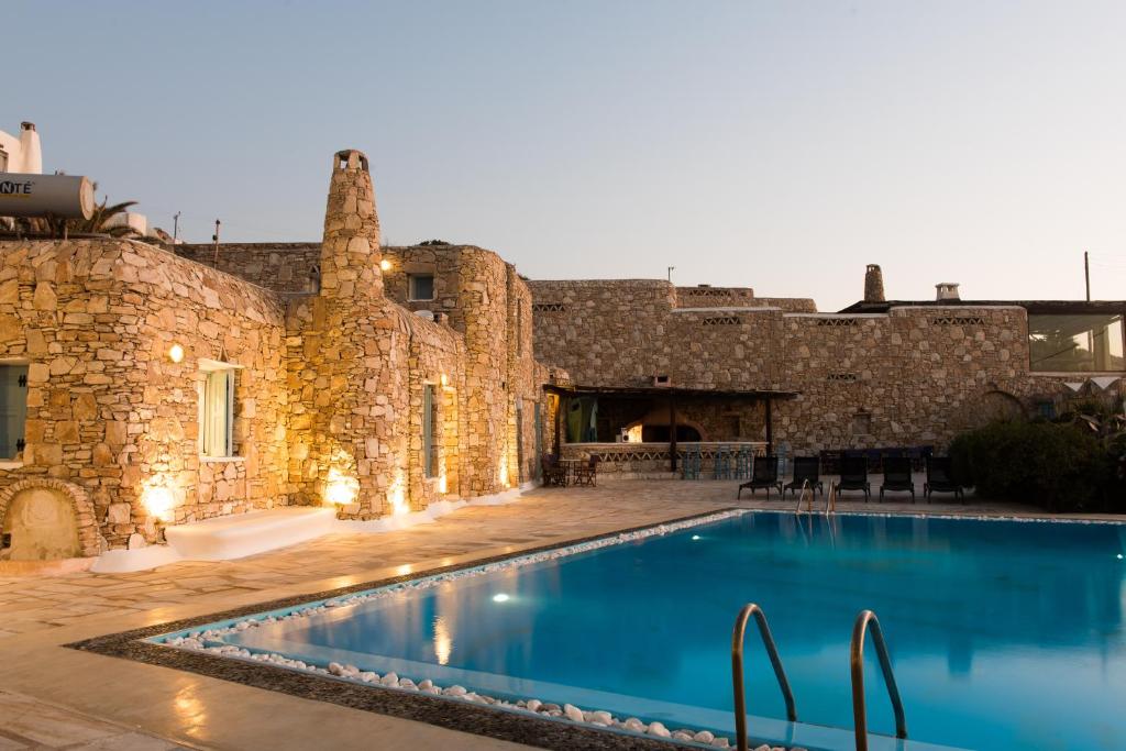 a swimming pool in front of a stone building at Villa Boufla in Agios Ioannis Mykonos