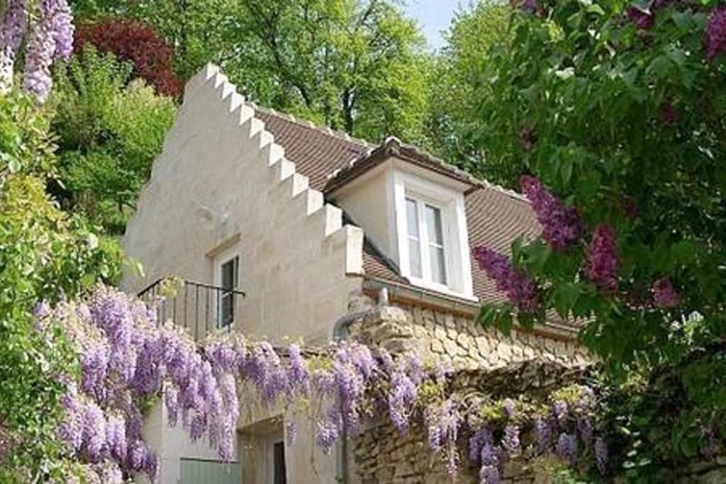 une maison avec des fleurs violettes devant elle dans l'établissement LES TERRASSES (centre de Pierrefonds), à Pierrefonds