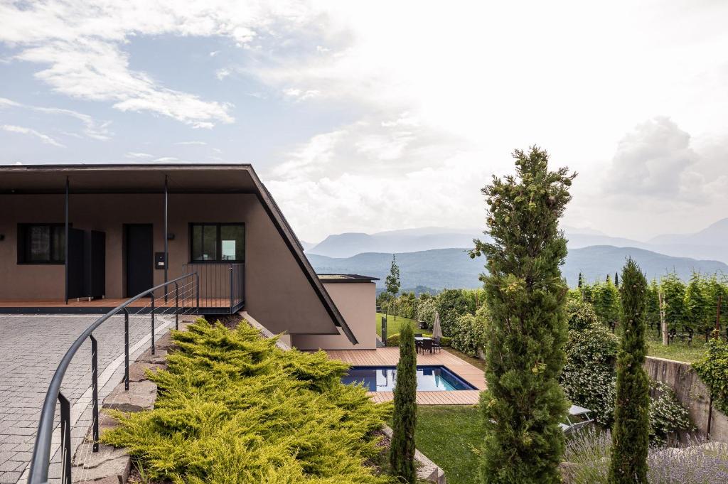 a house in the mountains with a swimming pool at Villa Pernstich - modern apartments in Caldaro