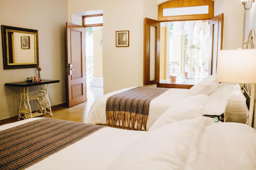 2 camas en una habitación de hotel con ventana en Hotel La Casona de Don Jorge, en Colima