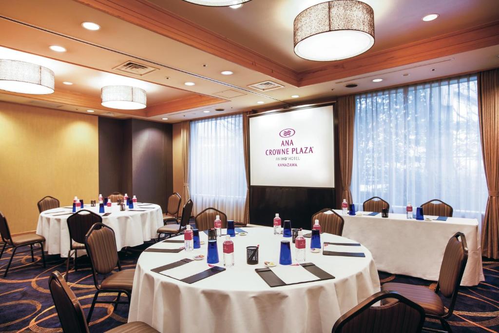 a conference room with tables and chairs and a screen at ANA Crowne Plaza Kanazawa by IHG in Kanazawa