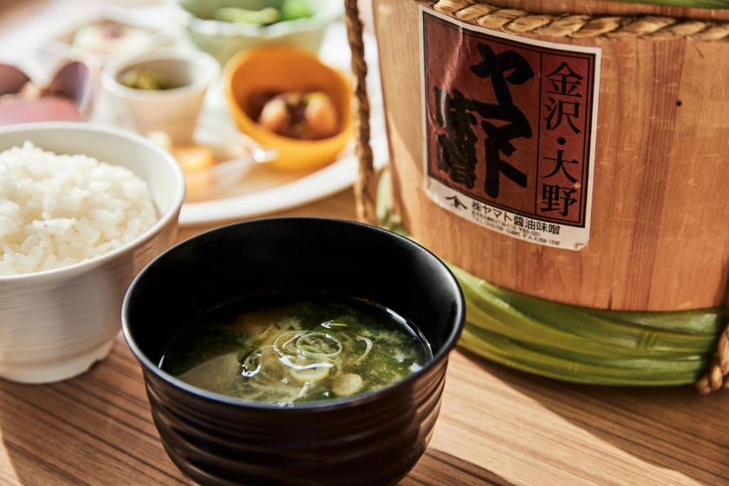 a bowl of soup next to a container of rice at ANA Crowne Plaza Kanazawa by IHG in Kanazawa