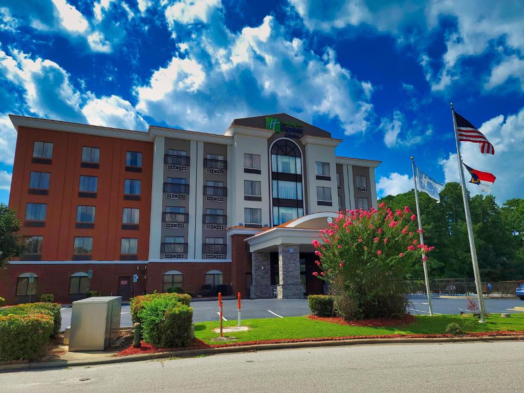 un hotel con una bandera americana delante de él en Holiday Inn Express & Suites Wilson-Downtown, an IHG Hotel, en Wilson