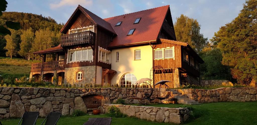 a large house with a stone wall at Dom Jesionów in Idzików