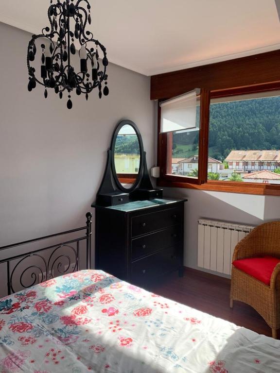 a bedroom with a bed and a dresser and a mirror at Apto Rio Asón, desconexión total con Piscina y vistas espectaculares in Gibaja