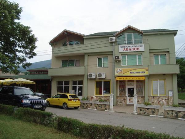 a yellow car parked in front of a building at Хотелски Комплекс Авалон in Asenovgrad