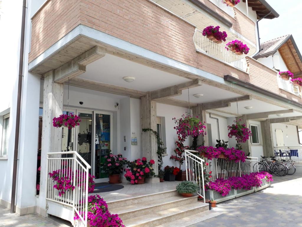 un edificio con fiori rosa sui gradini e sui fiori di Residence ONDA BLU 2 a Cervia
