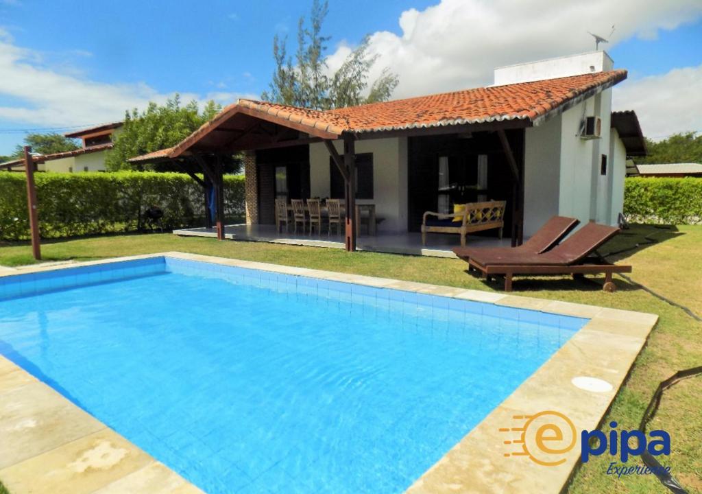 a villa with a swimming pool and a house at Pipa Casa Petit (Condomínio Pipa Natureza) in Pipa