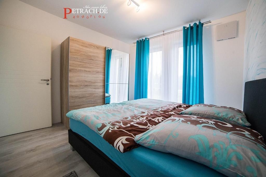 - une chambre avec un lit doté de rideaux bleus dans l'établissement Comfort Apartment Oldenburg, à Oldenbourg