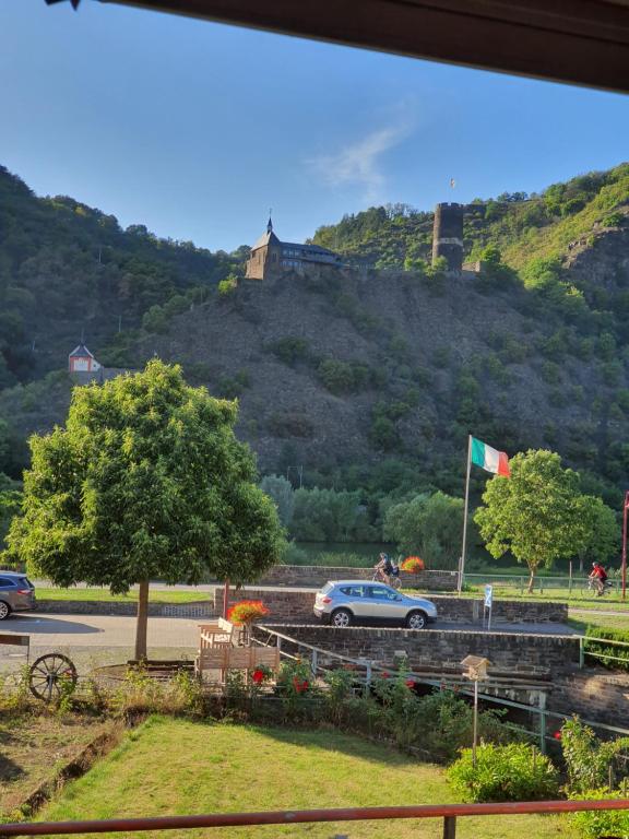 une voiture garée sur une route avec un château sur une colline dans l'établissement Burgener Burgblick, à Burgen