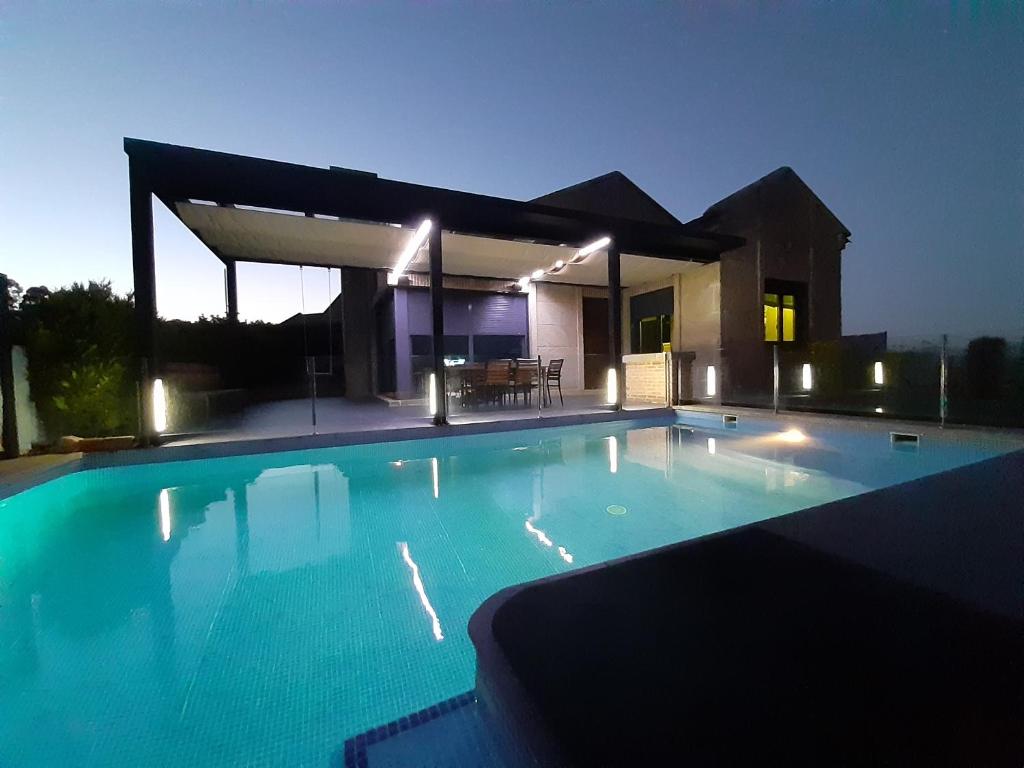 a swimming pool in front of a house at night at La Casa de Sofía en Tui in Tui