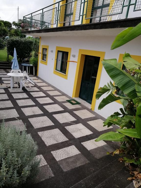 a courtyard of a house with a table and a umbrella at apartamento cinco reis in Angra do Heroísmo