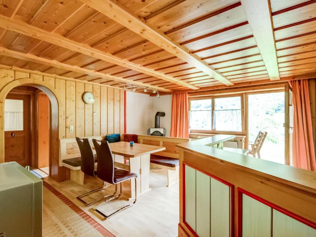 a kitchen and dining room with a wooden ceiling at Apartment on the mountainside in Silbertal in Silbertal