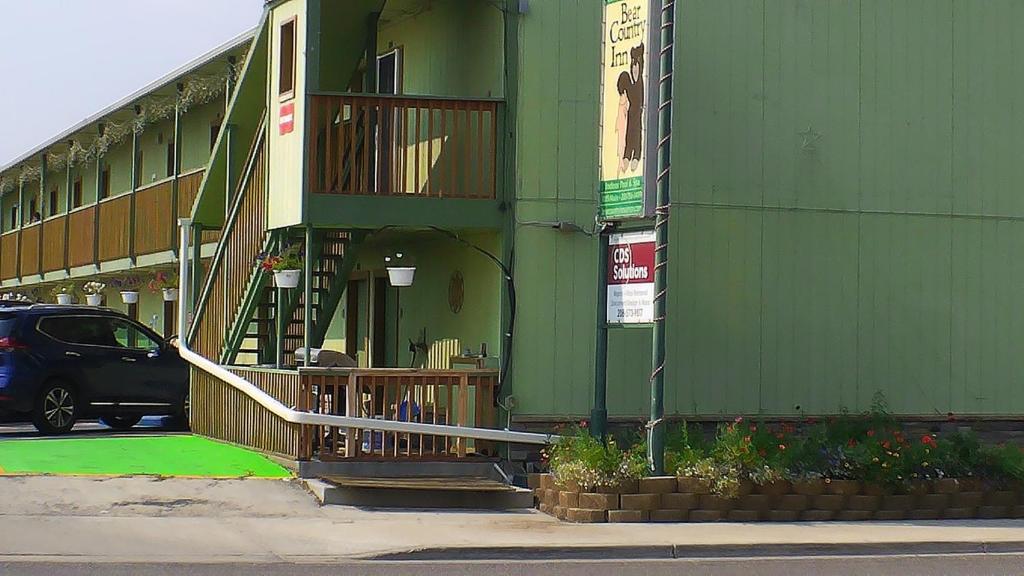 un bâtiment vert avec une voiture garée devant lui dans l'établissement Americas Best Value Inn, à Salmon