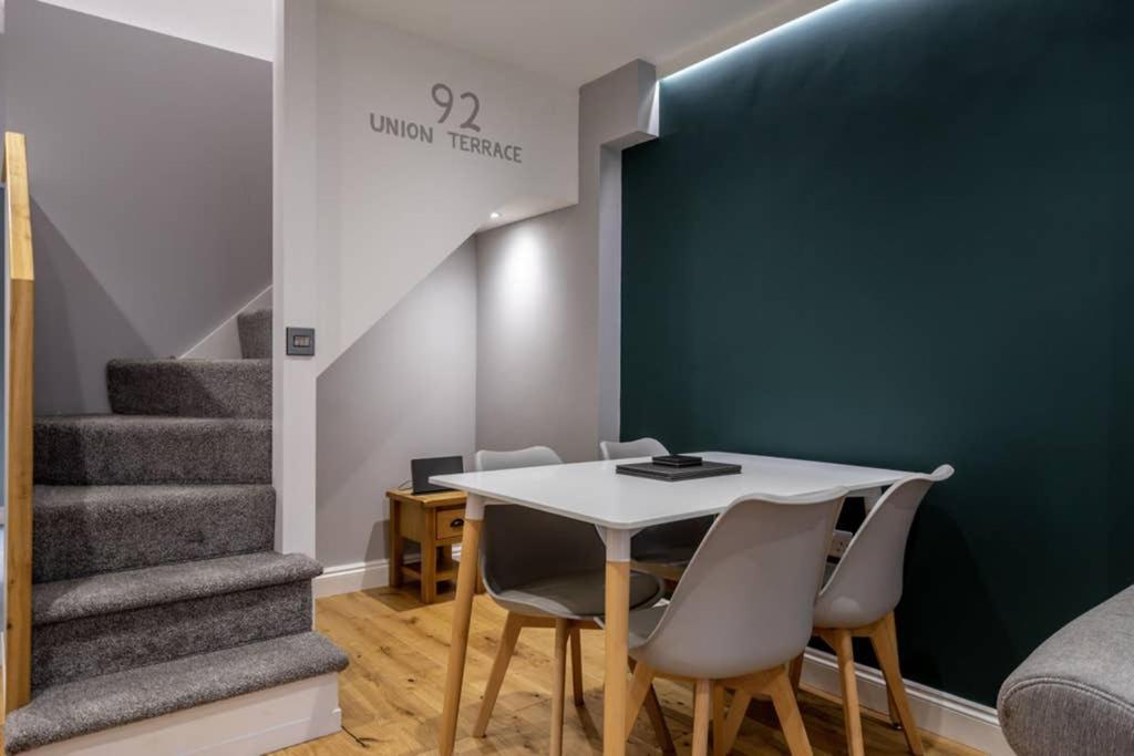 a dining room with a table and chairs and stairs at 92 Union Terrace in York