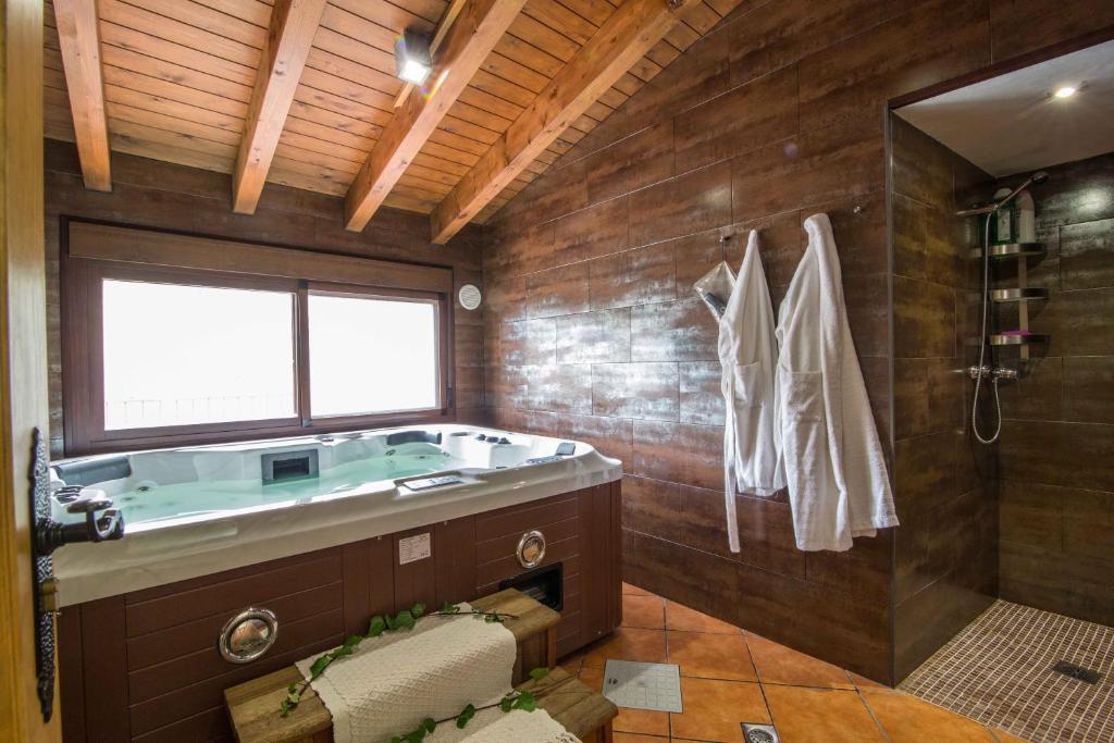y baño con bañera grande y ducha. en Casas Rurales Picachico, en Laroya
