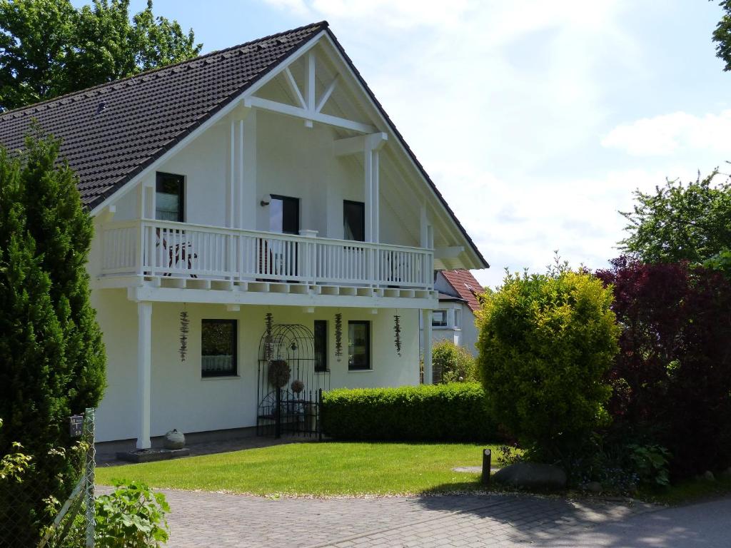 奧斯特巴德·哥倫的住宿－Haus NORDLICHT，带阳台和庭院的白色房屋