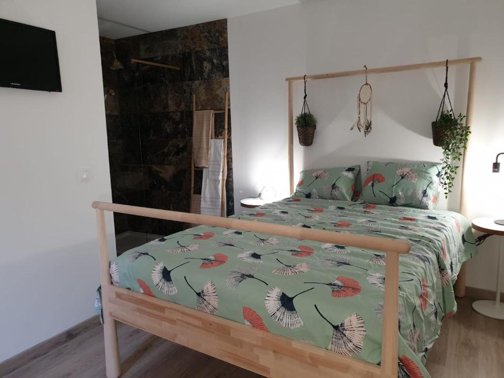 1 dormitorio con 1 cama con edredón verde en CASAS BEM HAJA Praça e Oliveira, en São Miguel de Acha