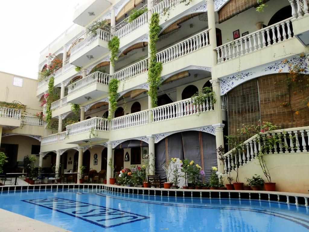 a hotel with a swimming pool in front of a building at Jasvilas in Jaipur