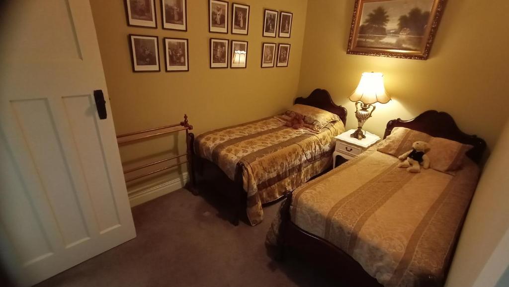 
a bedroom with two beds and two lamps at Blakes Manor Self Contained Heritage Accommodation in Deloraine
