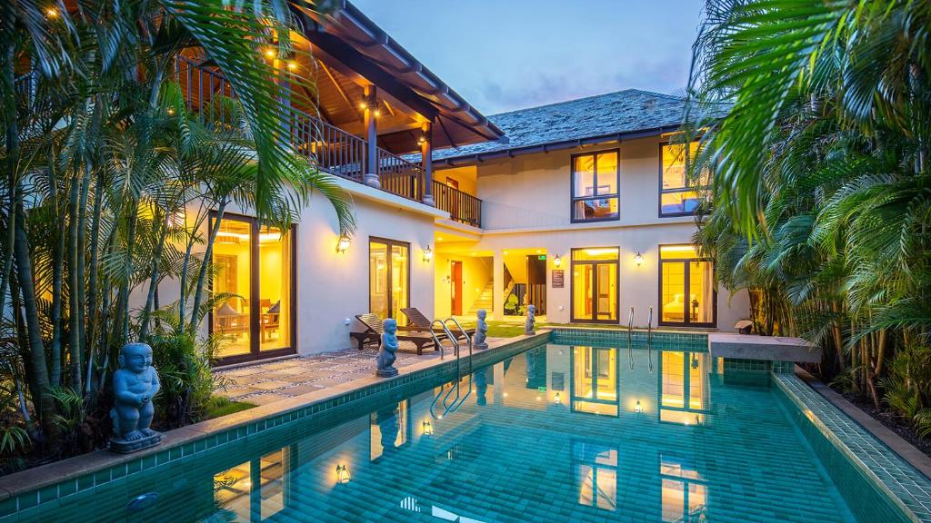 uma casa com piscina em frente a uma casa em Sanya Yalong Bay Villas & Spa em Sanya