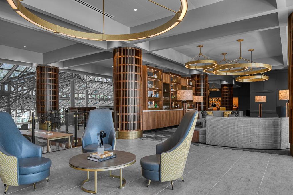 a lobby with chairs and a table and a bar at Crowne Plaza Atlanta Perimeter at Ravinia, an IHG Hotel in Atlanta