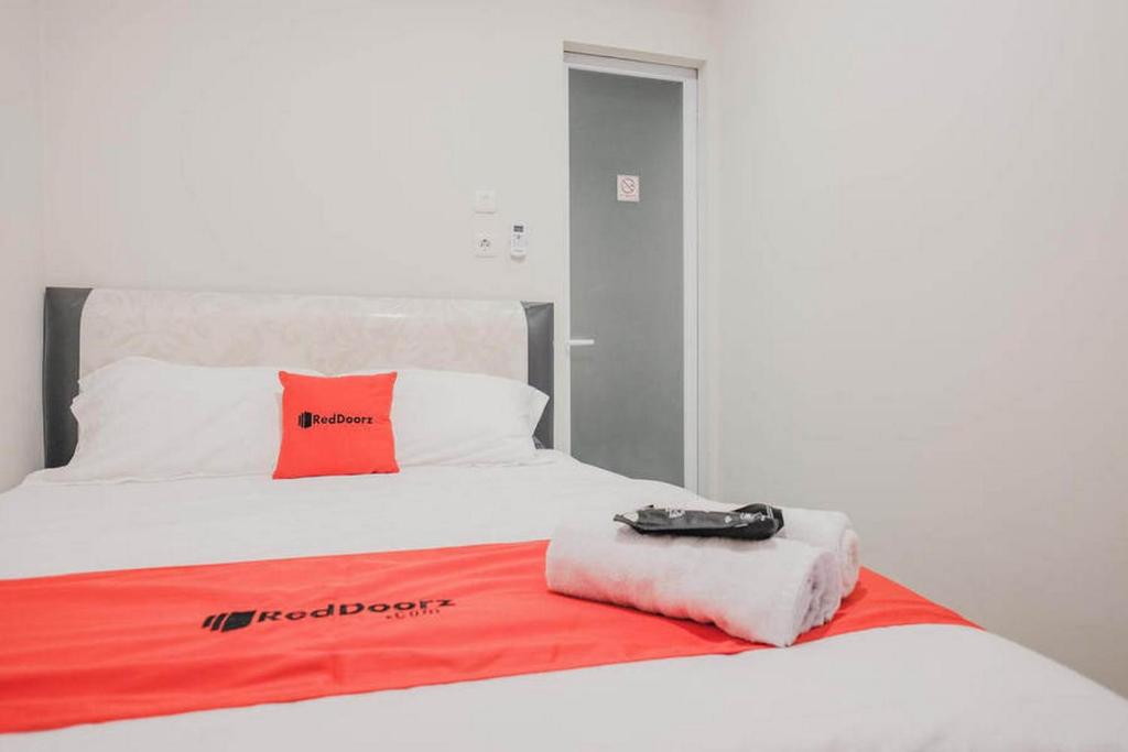 Postel nebo postele na pokoji v ubytování RedDoorz Plus near Soekarno Hatta Airport Taman Mahkota