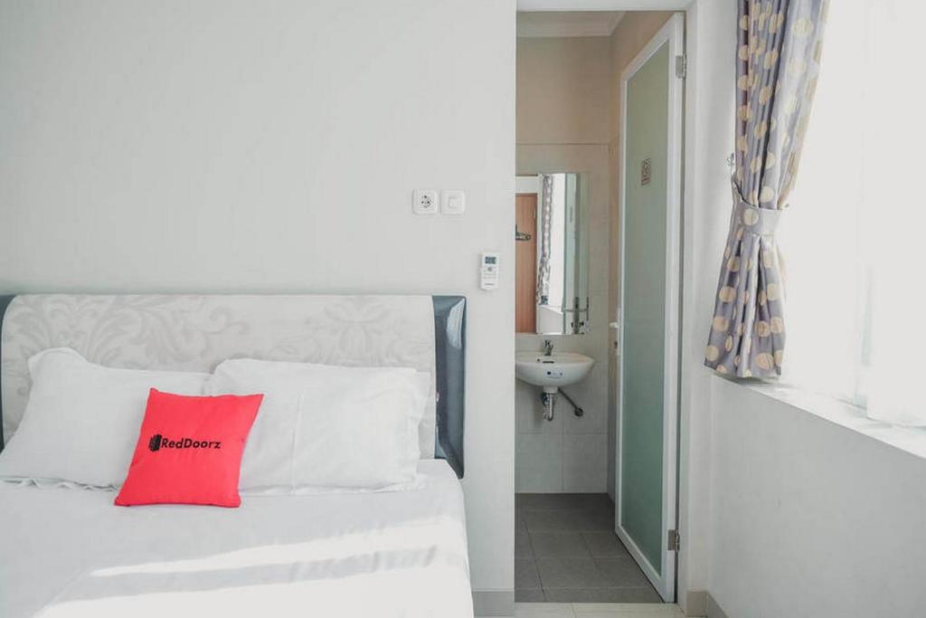 Postel nebo postele na pokoji v ubytování RedDoorz Plus near Soekarno Hatta Airport Taman Mahkota