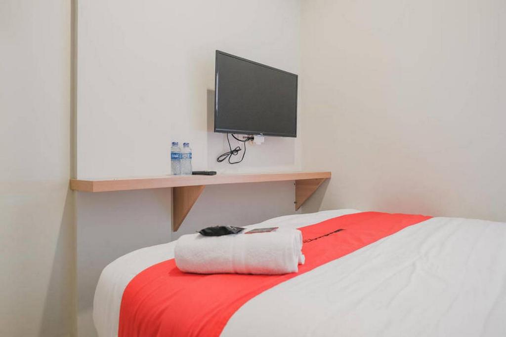 Postel nebo postele na pokoji v ubytování RedDoorz Plus near Soekarno Hatta Airport Taman Mahkota