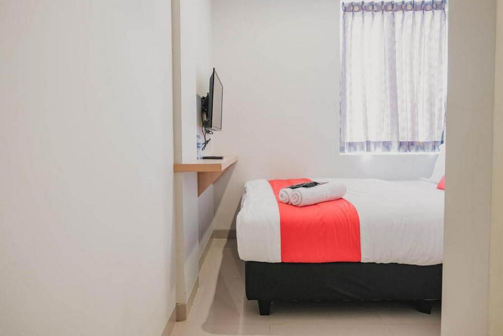Postel nebo postele na pokoji v ubytování RedDoorz Plus near Soekarno Hatta Airport Taman Mahkota